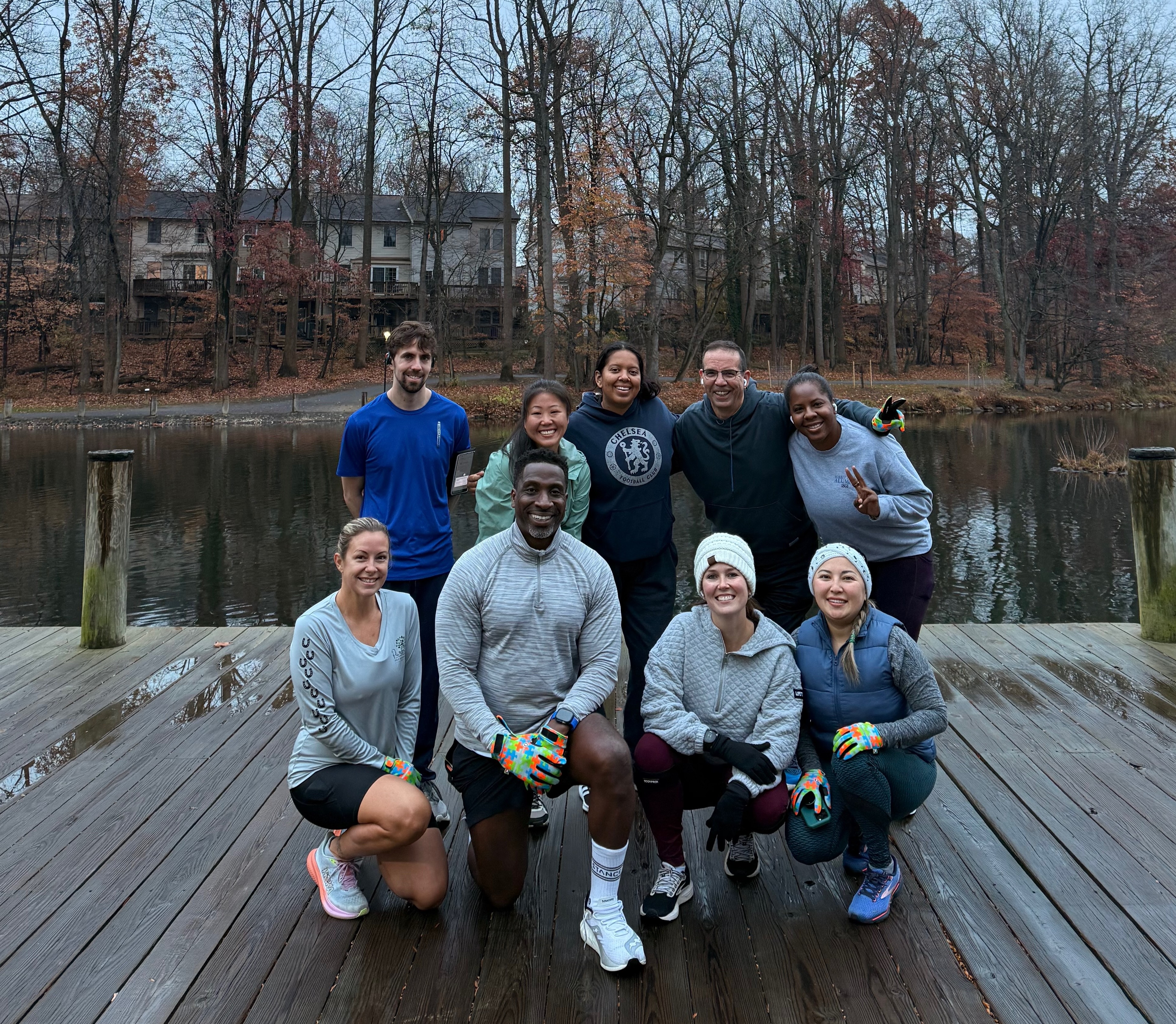 Run club members gathering together on dock by lake